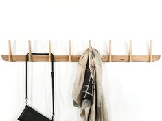 a coat rack with two purses hanging on it