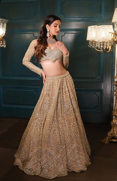 This lehenga set is hand embroidered in floral and geometric motis with a mix of light gold and sequin embroidered. Paired with a full sleeves embroidered wide-neck blouse and match dupatta.DELIVERY TIMEPlease allow 8-12 weeks for your outfit to arrive.FABRIC DETAILSNetProfessional cleaning only.