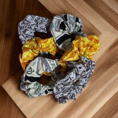 dollar bills are wrapped around a scarf on top of a wooden table