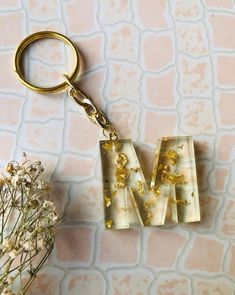 the letter m is made out of glass and has gold flecks on it