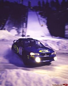 a car is driving through the snow at night