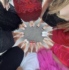 several women standing in a circle with their hands together