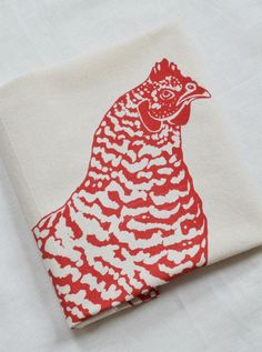 a red and white chicken on a linen napkin