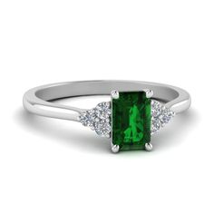 an emerald ring with three diamonds on the side