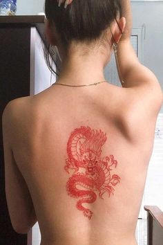 a woman with a dragon tattoo on her back