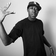 a black and white photo of a young man holding his hands up in the air