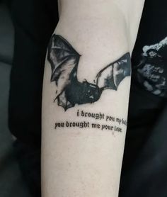 a bat tattoo on the left arm with words written below it that says, i brought you my love