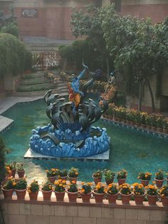 the fountain is surrounded by potted plants and flowers