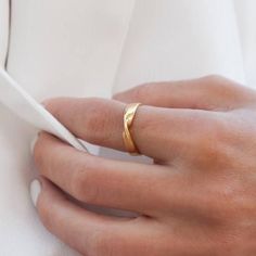 a woman's hand with a gold ring on it