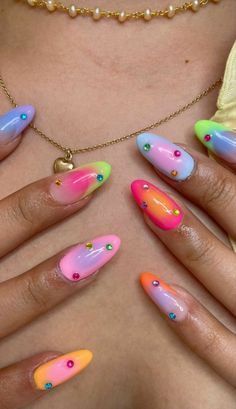 the woman is wearing colorful nail designs on her nails