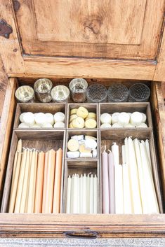 an old wooden box filled with candles and other items