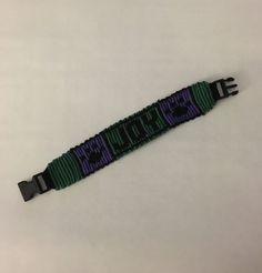 a purple and green bracelet with the word love spelled on it's end loop