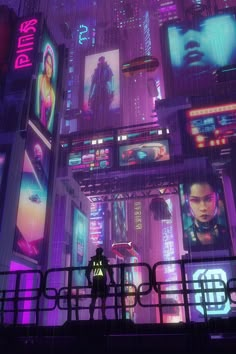 a man standing on top of a bridge next to tall buildings covered in neon lights