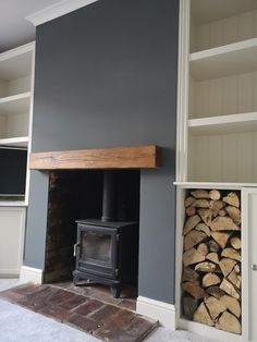 a wood burning stove sitting next to a stack of firewood