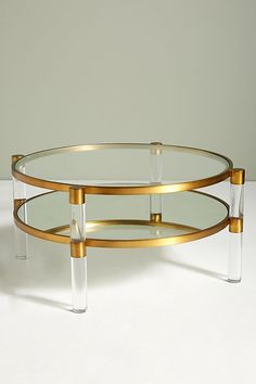 a glass and brass coffee table on a white surface