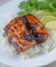 salmon and rice on a white plate with lime wedges