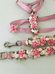 pink and white flowers are attached to the collars, leashes, and lanyard