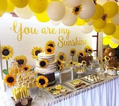 there is a table with sunflowers and desserts on it