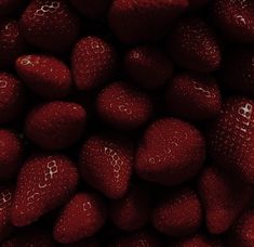 a pile of red strawberries is shown in this image