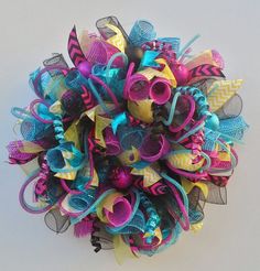 a close up of a colorful wreath on a white surface