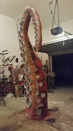 an octopus sculpture made out of cans in a garage