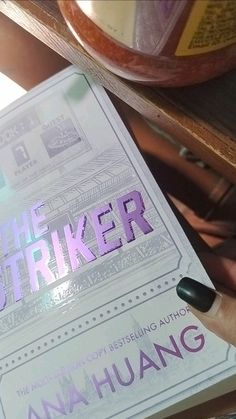 a person holding up a book with the word the strikeker written in purple on it