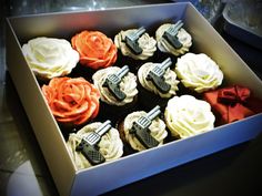 a box filled with cupcakes covered in white frosting and orange icing