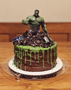 a hulk cake with green icing on a wooden table