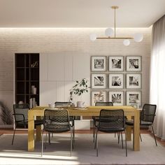 a dining room table with chairs and pictures on the wall