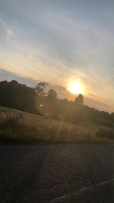 the sun is setting over an open field