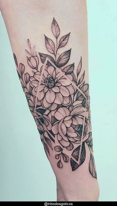 a black and white flower tattoo on the right leg, with an arrow in the middle