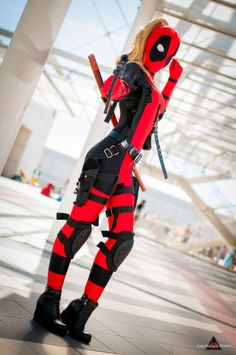 a woman dressed in deadpool cosplay poses for the camera