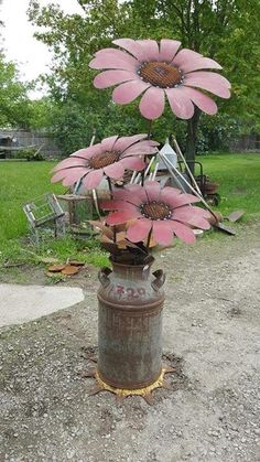 some pink flowers are in a rusty vase