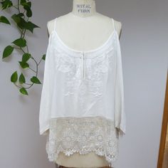 One New With Tags Ecote White Embroidered Off Shoulder Bohemian Tunic With Crochet Trim Labeled Size Small. Runs Extremely Oversize For A Size Small, It Can Fit Up To An Xl With A Regular, Loose Fit. Measurements Laid Flat Are: Length Is 28", Bust Is 21", Waist Is 23", Hips Are 25". Original Price Was $79.00. This Top Has Never Been Worn. This Top Features Strappy Shoulders, Embroidered Flowy Sleeves And Bodice, A Front Hook At The Bottom Of The Neckline, And A Long Crochet Detail At The Hem. Fa White Lace Tops For Summer, Summer Bohemian Blouse With Lace Work, Bohemian Summer Blouse With Lace Work, Summer Bohemian Blouse With Lace Patchwork, Bohemian Lace Work Tops For Vacation, Beach Lace Blouse With Embroidery, Beach Lace Embroidered Blouse, White Lace Vacation Tops, White Lace Summer Blouse