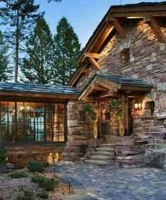 a stone house with lots of windows and steps leading up to the front door,