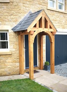 a wooden gazebo sitting in front of a brick building next to a green lawn