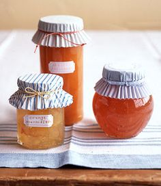 three jars of honey sitting on top of a table