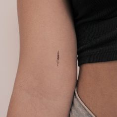 a woman's arm with a tiny tattoo on the left side of her arm