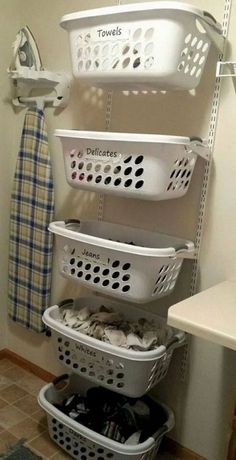 several laundry baskets stacked on top of each other next to a towel rack in a bathroom