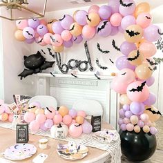 a table topped with lots of balloons and bats