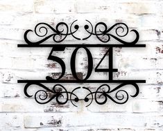 a metal sign that reads 504 on the side of a brick wall with an iron frame