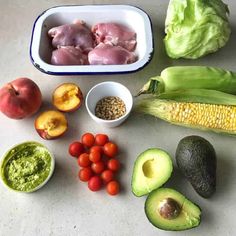 an assortment of fruits, vegetables and meats are laid out on a counter top