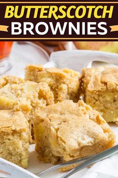 butterscotch brownies on a white plate with a fork and cup in the background