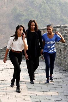 three women walking on the great wall of china, one talking on her cell phone