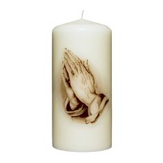 a white candle with a praying hand on it