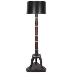 a lamp that is on top of a wooden stand with a black lampshade