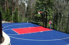 an outdoor basketball court surrounded by trees