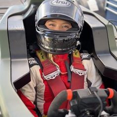 a woman in a racing car wearing a helmet