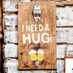 a wooden sign that says i need a hug class of beer on it next to a brick wall