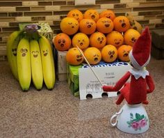 an elf is standing on top of a fruit stand with oranges and bananas in the background